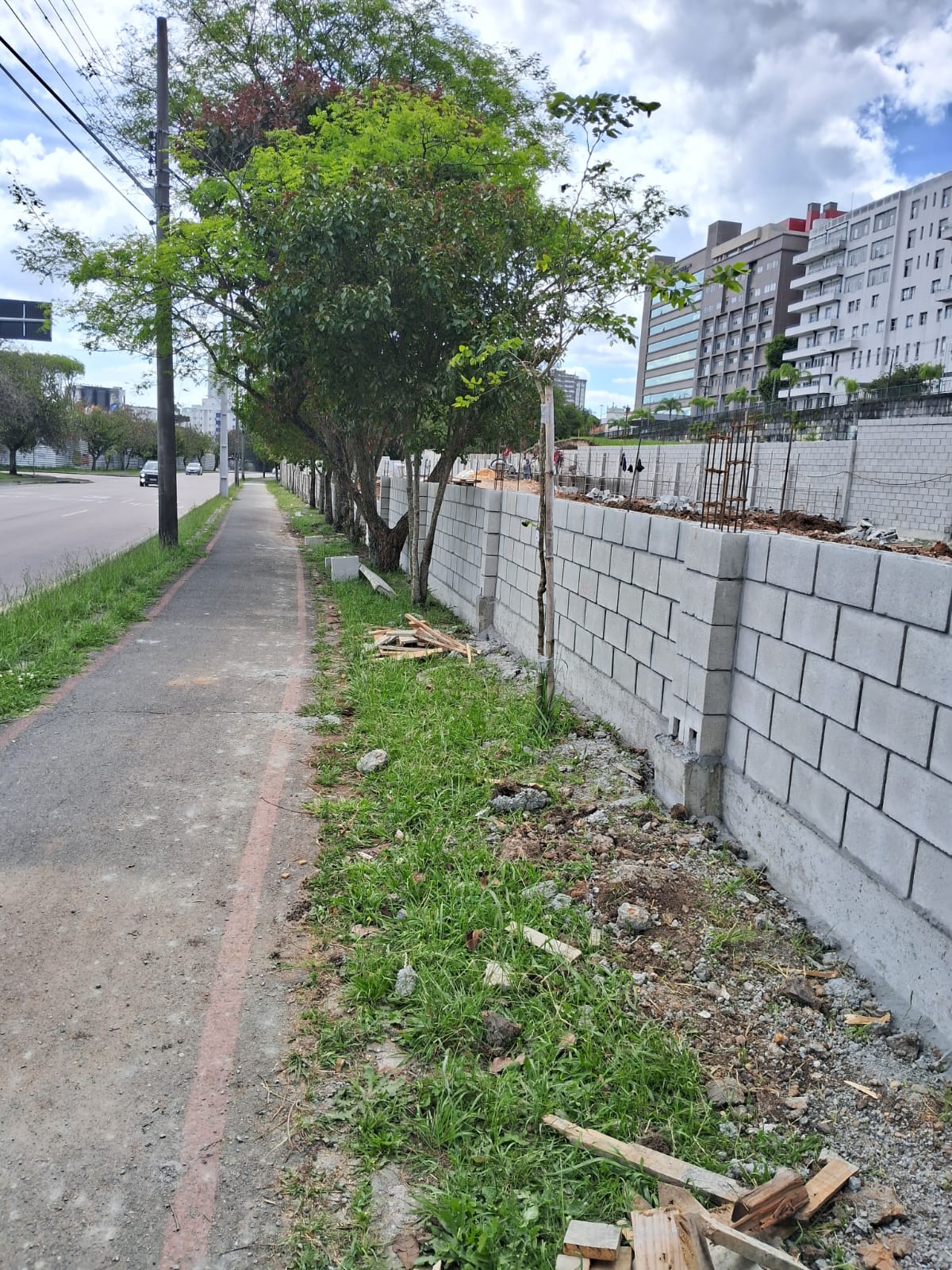 Muro de tijolos em construção ao longo de calçada