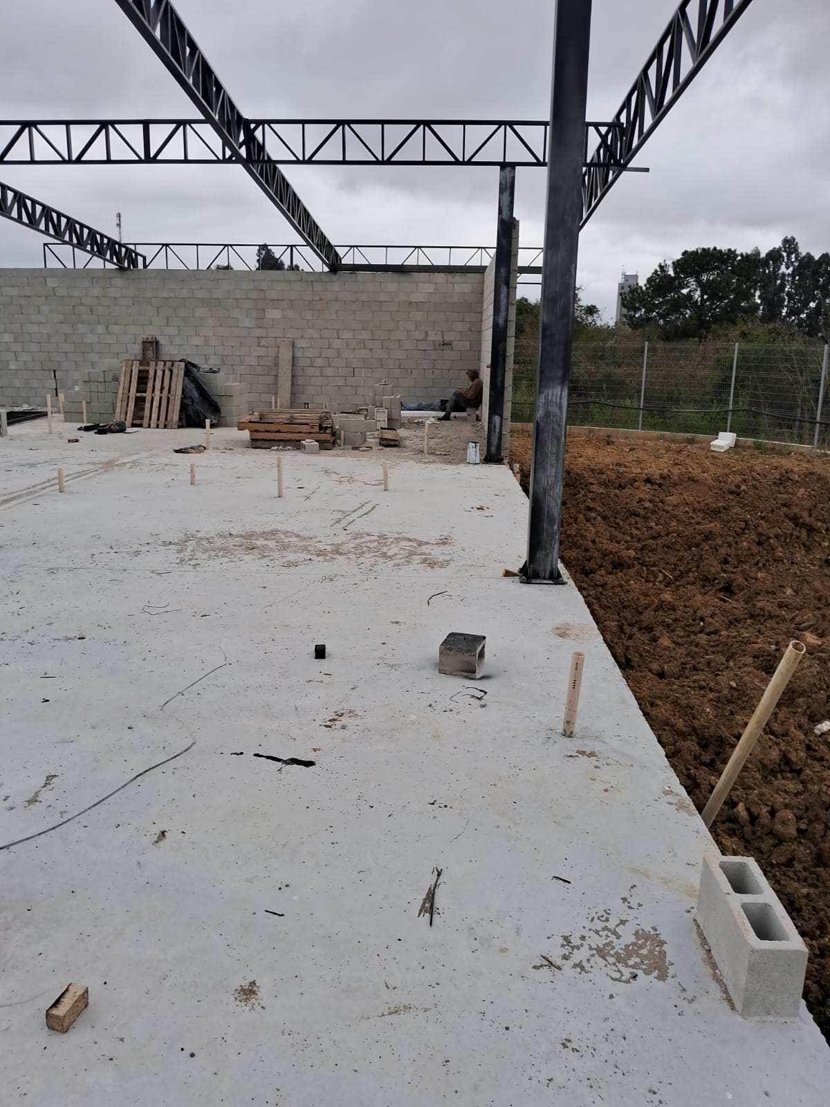 Estrutura metálica e alvenaria de galpão em construção